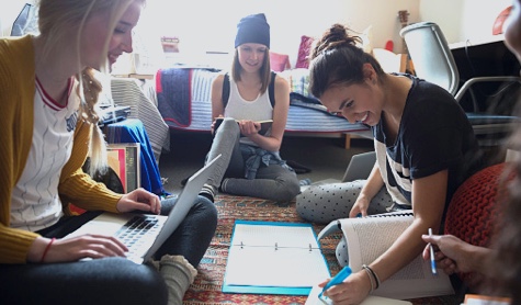 Group of female students studying on the floor in a room